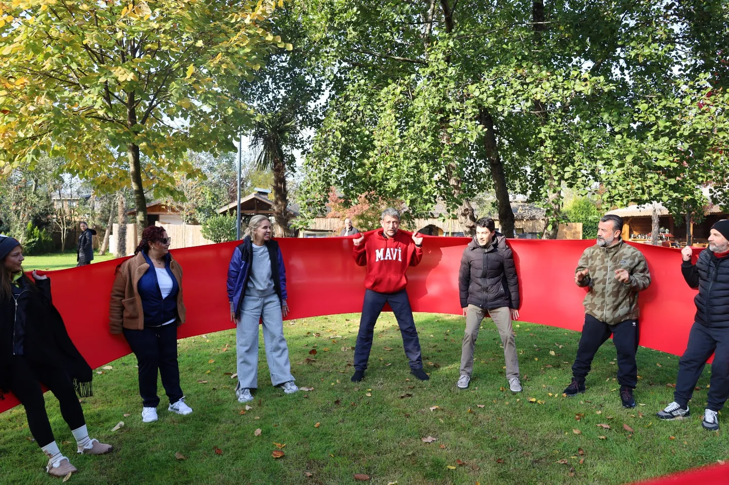 Katılımcılar bahçede birlikte bir grup egzersizi yaparken